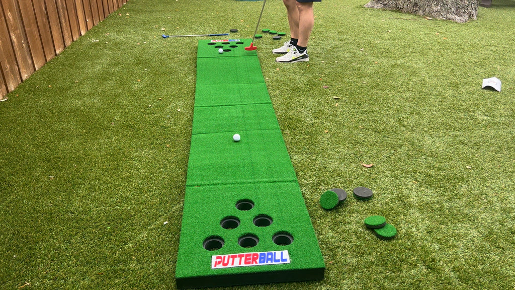 Man stands in backyard putting golf balls on Putterball game.