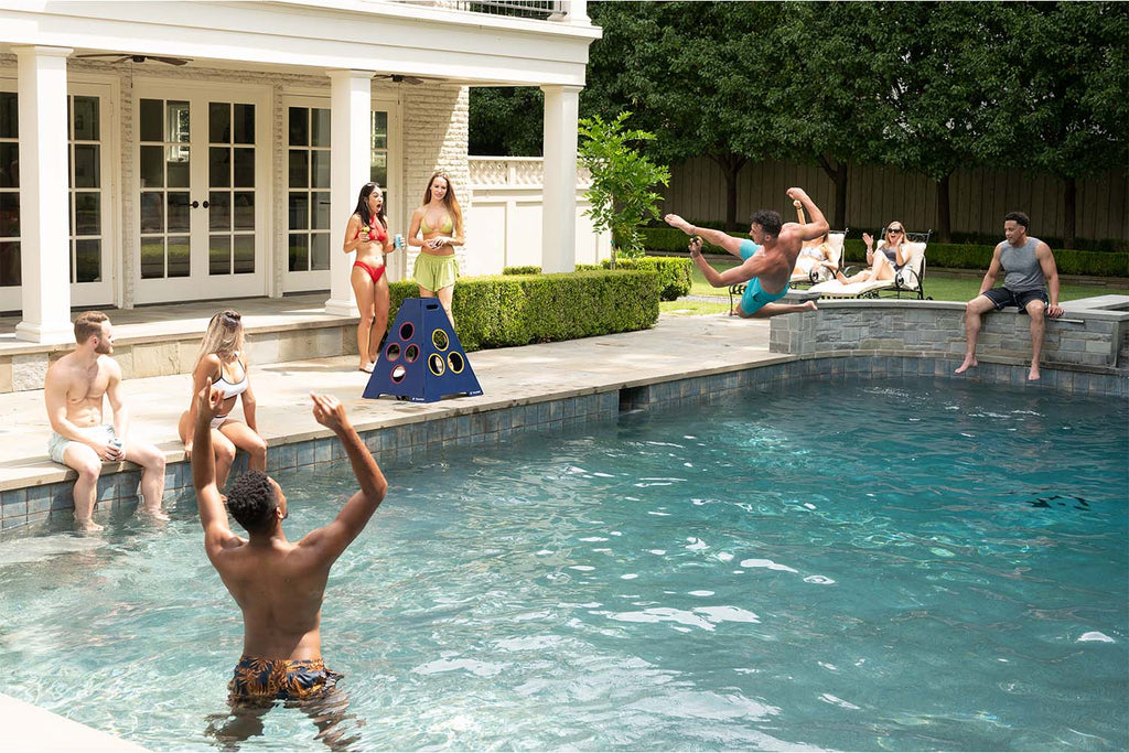 Group of adults playing TowerBall by Caliber Games next to the pool