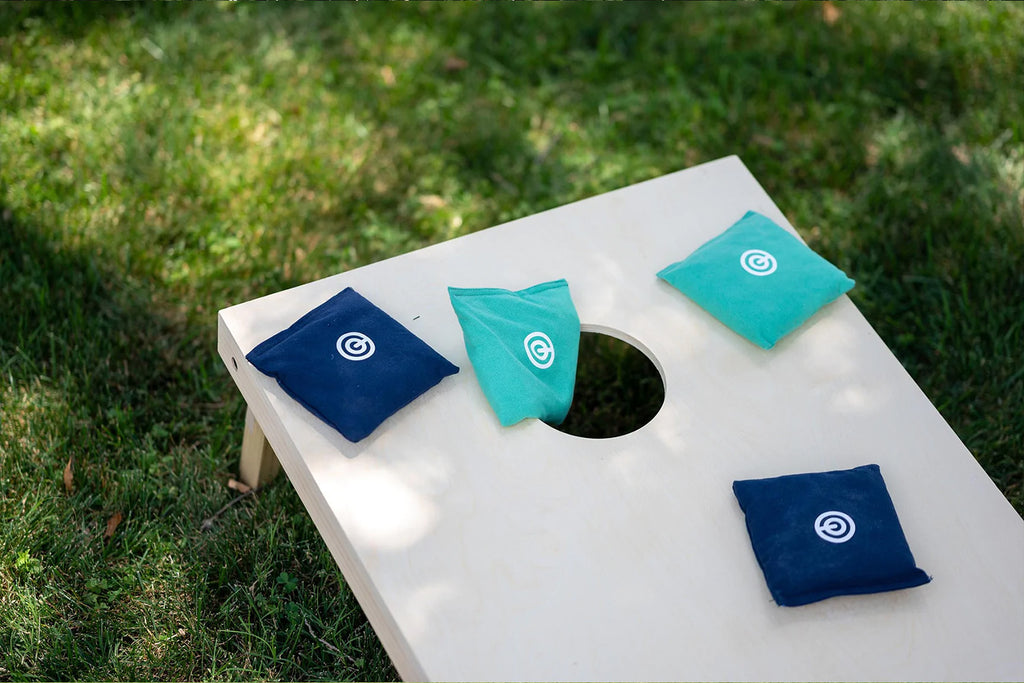 Cornhole tailgate game on top of grass at the park