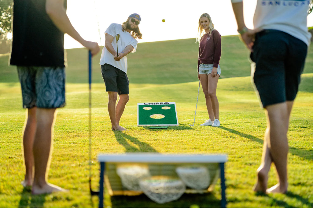 Friends playing Chippo a backyard game that combines cornhole and golf