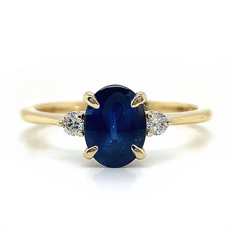 an oval shaped blue sapphire set with one diamond on each side