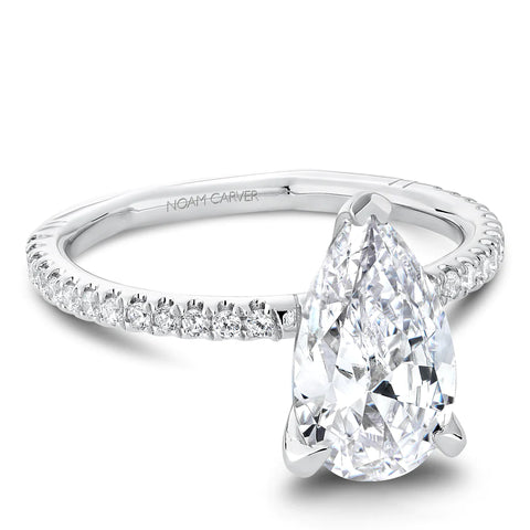 a teardrop shaped diamond sits on a narrow white gold diamond band