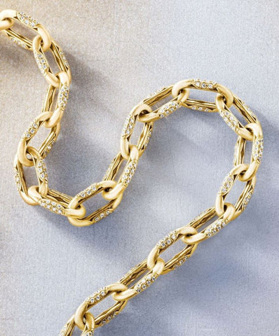a yellow gold link bracelet with sections of round cut diamonds