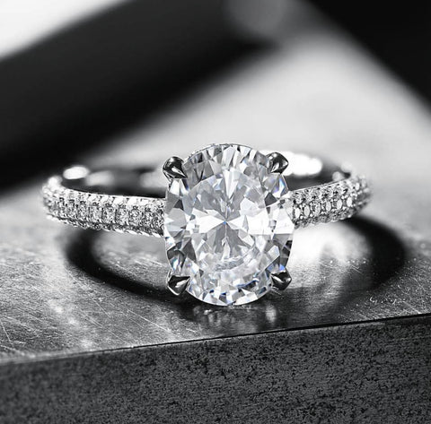 an oval cut diamond engagement ring on a pave band