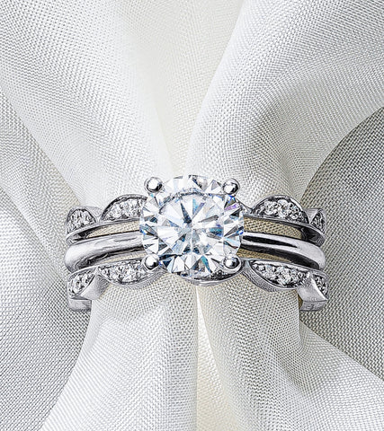 a white gold diamond solitaire with scalloped wedding bands on each side