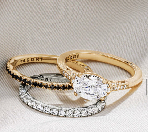 a yellow gold solitaire is paired with a black diamond band & a white diamond band