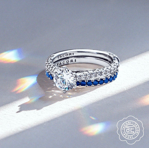 an engagement ring with white diamonds is paired with a wedding band of blue sapphires