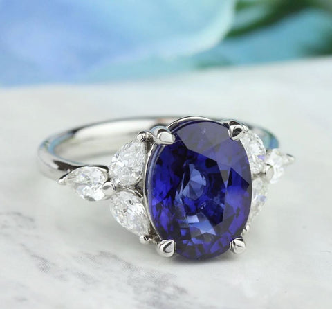 an oval cut blue sapphire with three marquise shaped diamonds on each side