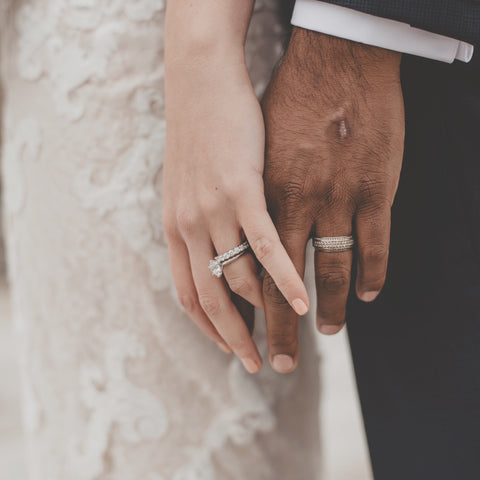 a bride wearing a diamond wedding set & a groom wearing a white gold wedding band