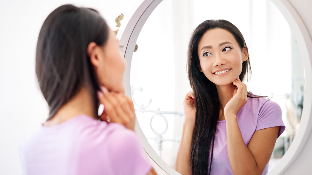 Blog: Confident Woman Smiling in Mirror Self Care