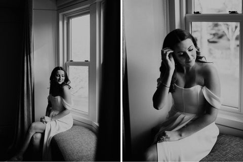 Bride posing for pictures before her wedding sitting on a window sill