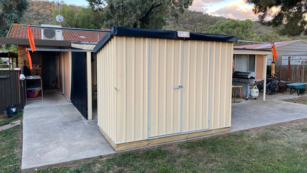 Smooth Cream Skillion Roof Shed in a garden