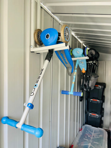 Tool holders attached on the shed with hanging scooters.