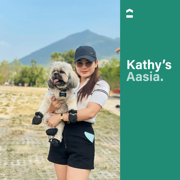 Girl holding a dog with a mountain at the back