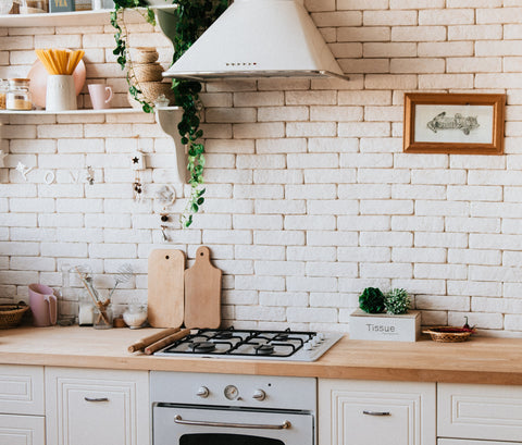 Cuisine cosy avec plan de travail en bois et carrelage en fond