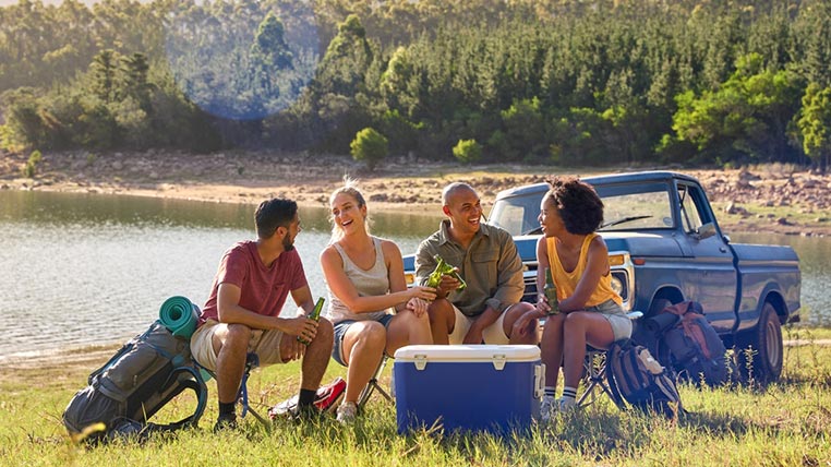 Group of friends sitting around a cooler