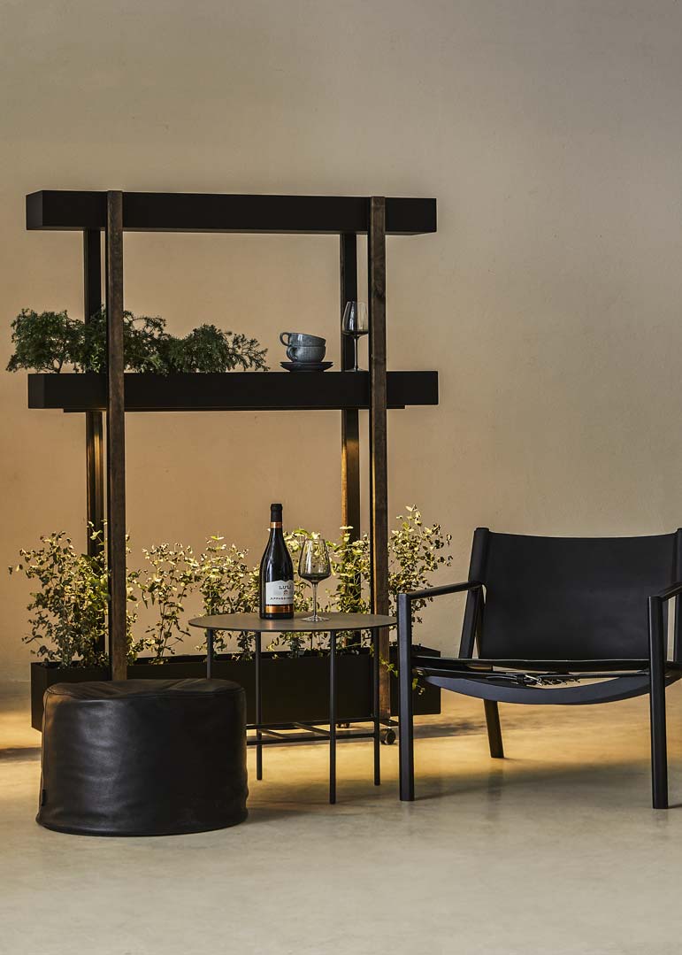 Lounge område møbleret med én stol, et bord og en S-model mobil rumdeler