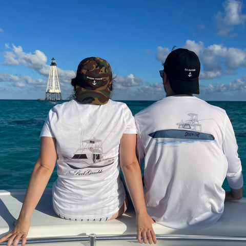 Two boaters wearing personalized boat shirts