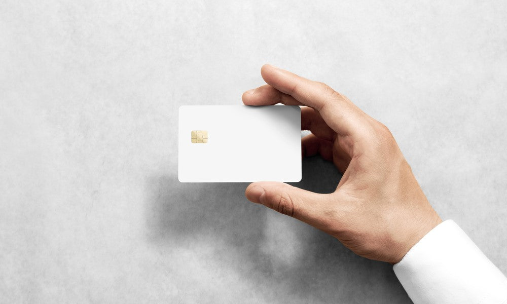 hand holding white card with chip