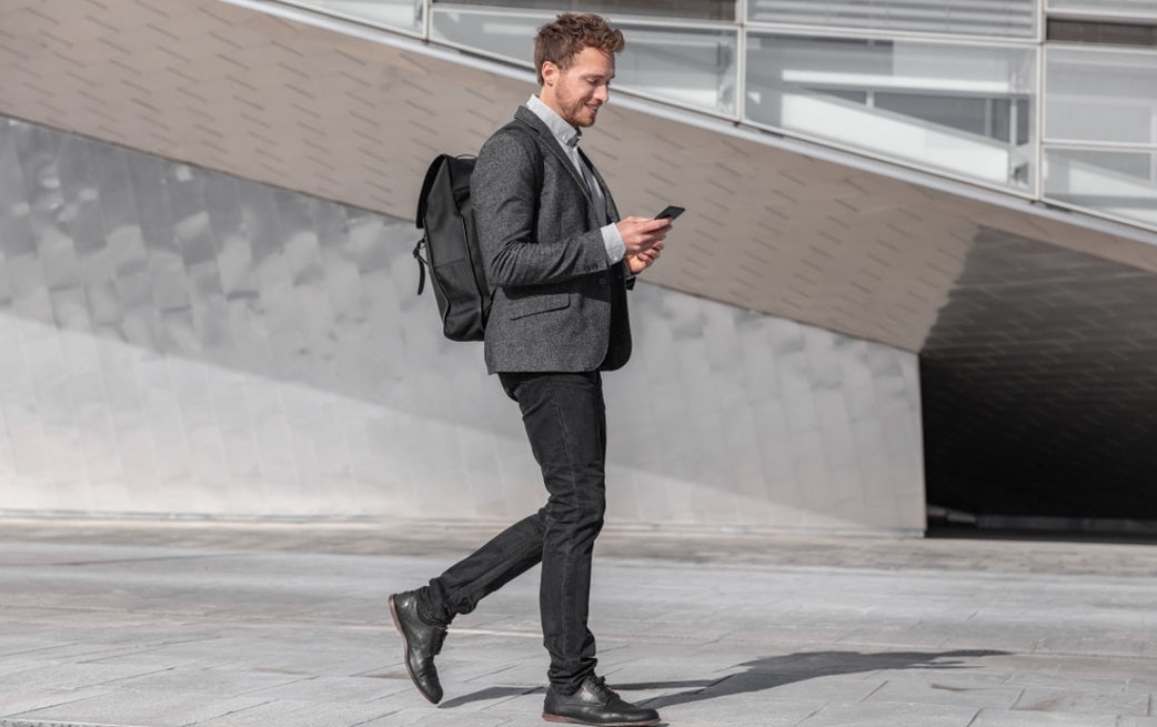 man walking on road with backpack