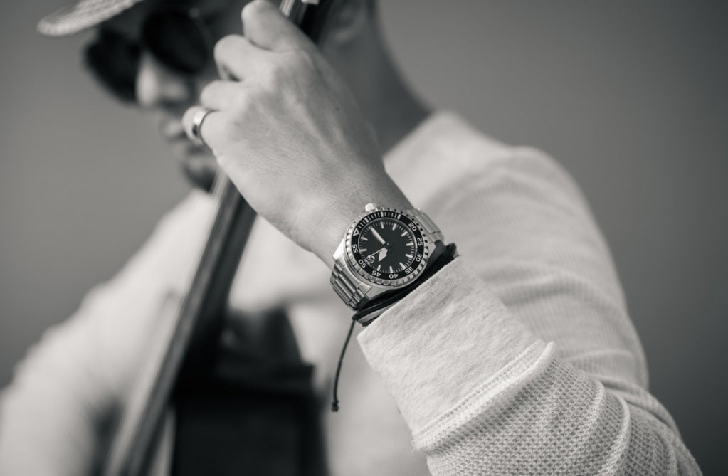 man wearing watch using musical instrument