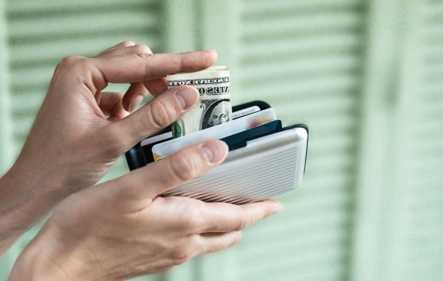 person putting money in RFID wallet