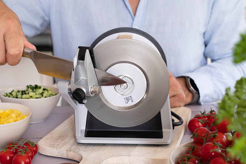 Man Sharpening a kitchen knife on Tormek T-1 for preparing sallad