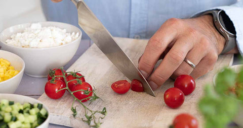 Man cutting a tomatoe for a sallad with a tormeksharp knife
