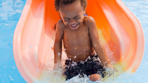 Little Boy Curly Hair Water Slide at Theme Park