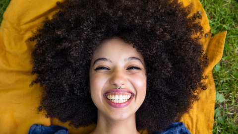 woman with 4b/4c hair afro laying in grass