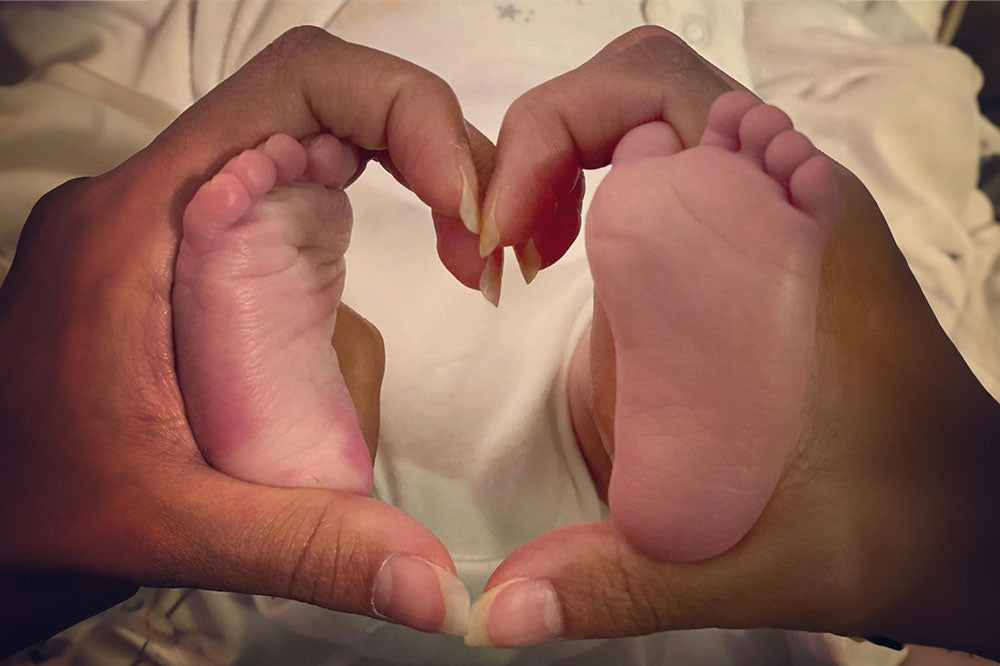 Sona holding baby Anveer's feet