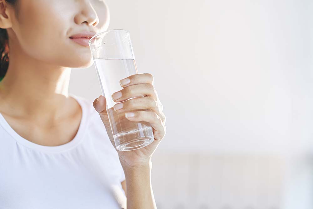 woman drinking water to keep hydrated