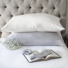 Silk pillowcases on a bed with a silk eye mask