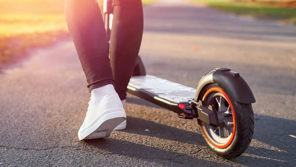 A person standing next to their e-scooter learning how to ride an electric scooter safely​