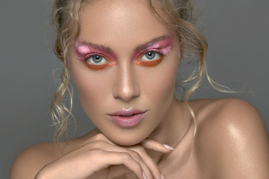 A portrait of a blonde woman with pink makeup.