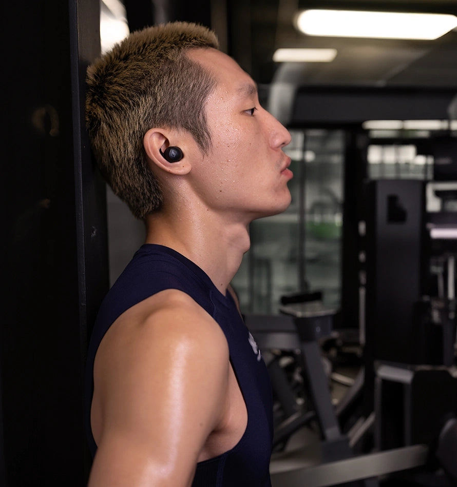 A men in the gym wears sennheiser momentun sport headphones