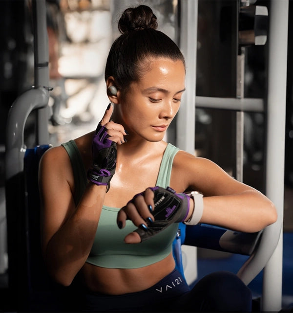 A womenen in the gym wears sennheiser momentun sport headphones
