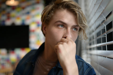 Portrait of a boy standing beside a window