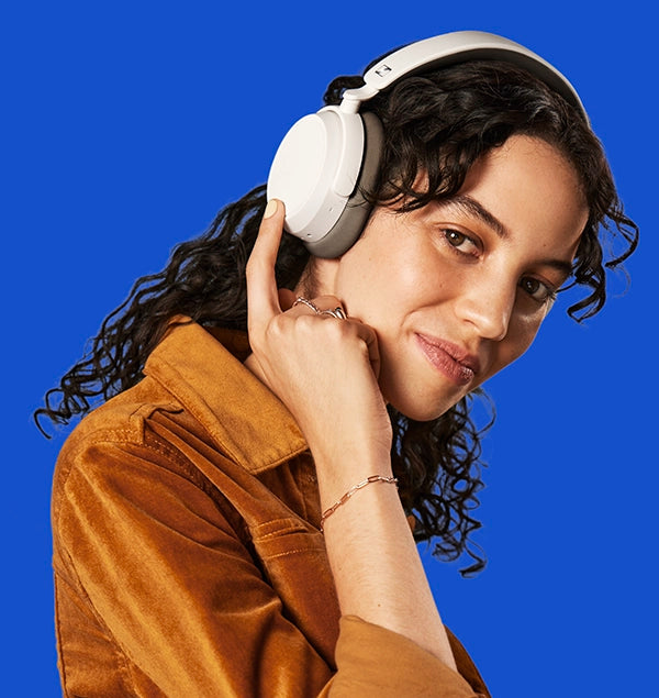 a Women wears white SENNHEISER ACCENTUM PLUS Headphones