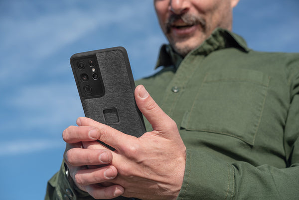 Man in green t-shirt holds Peak Design Samsung phone case