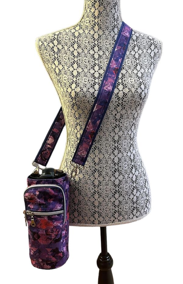 Floral-patterned crossbody water bottle holder on a lace-covered mannequin.