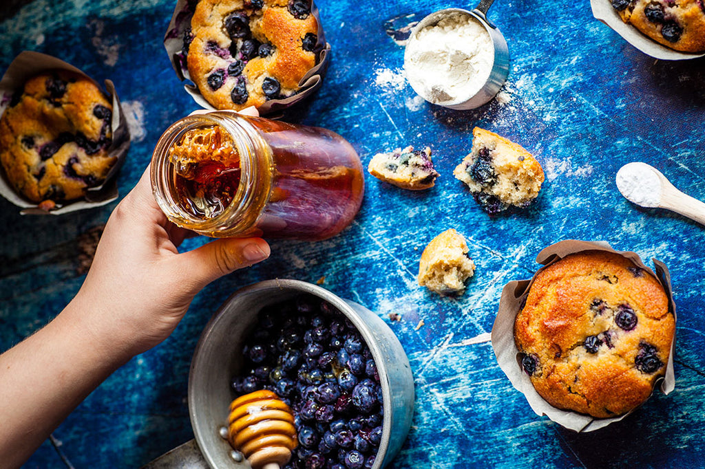 Muffins, blueberries, and honey on a table