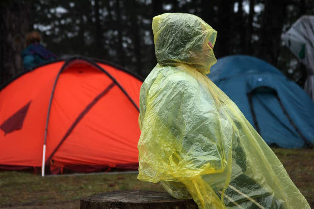 A person at a campsite wearing a raincoat