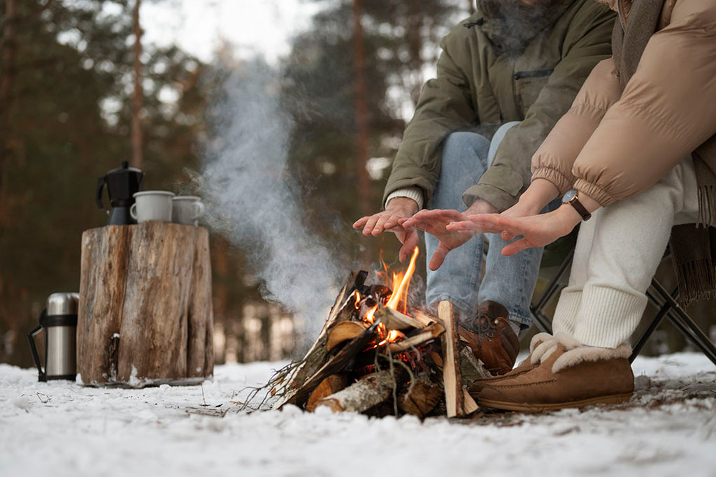 Couple warming their hands at a campfire