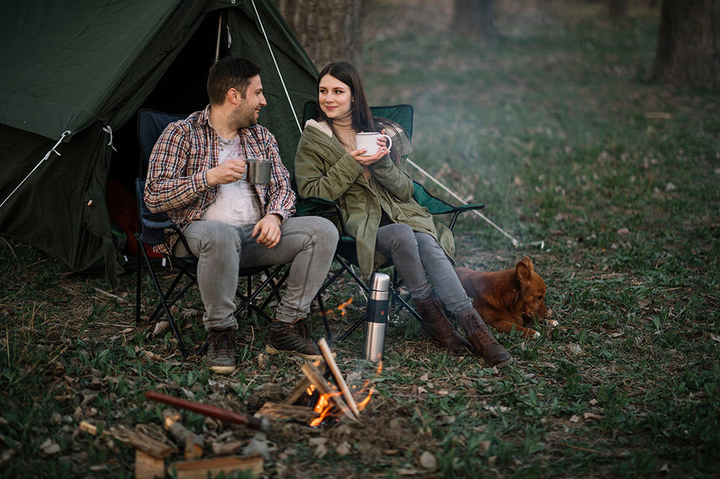 A couple with their dog having a coffee in nature