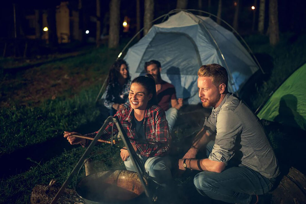 A group of friends cooking at a campsite