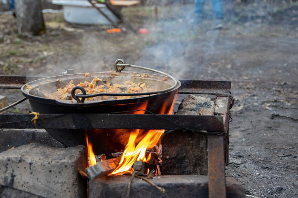 A meal being cooked in a pot at a campsite