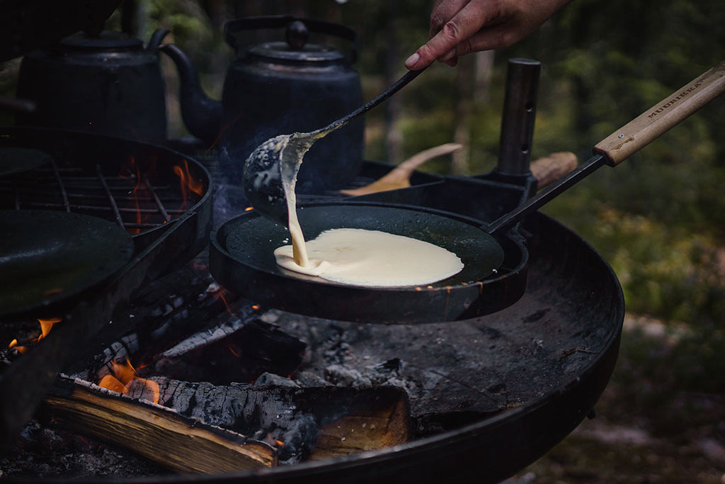 A pancake being cooked over a campfire