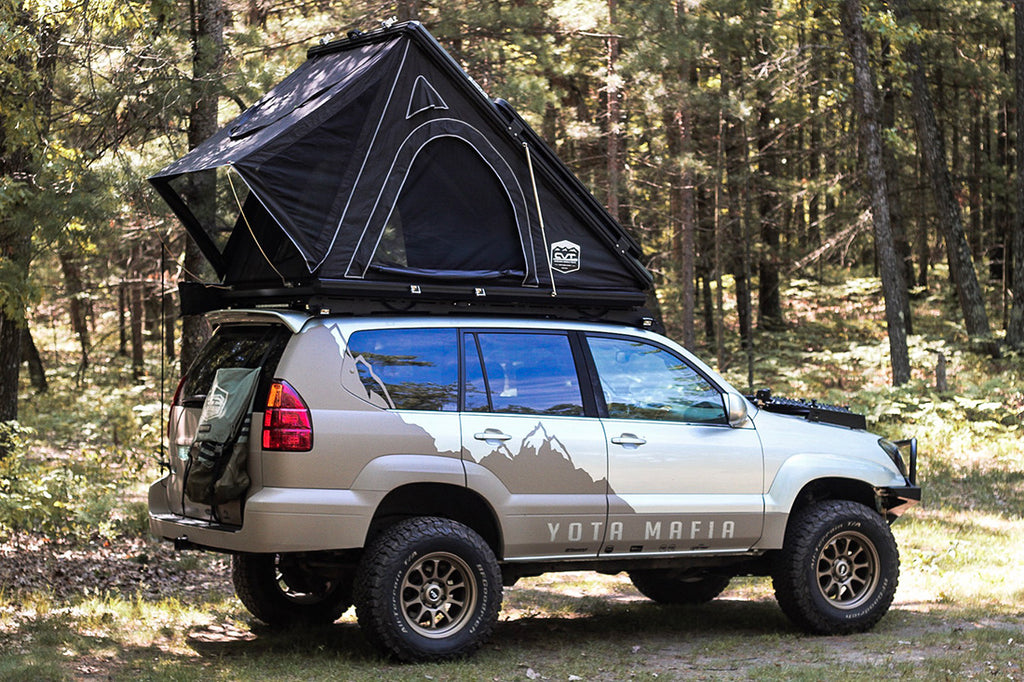 A car with a rooftop tent in a forest