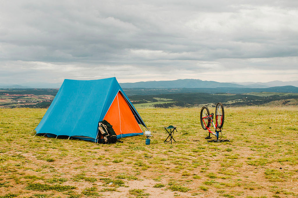 A bike parked outside a camping tent